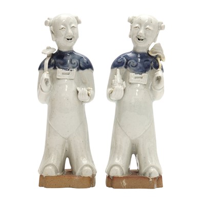 Lot 192 - A pair of Chinese glazed biscuit 'laughing boy' figures, Qing dynasty, Qianlong period