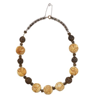 Lot 194 - A carved ivory bead necklace