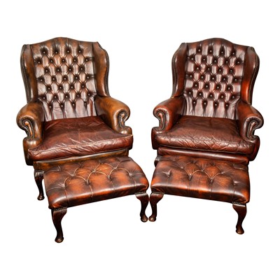 Lot 19 - A pair of brown leather wing back armchairs and stools