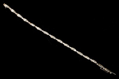 Lot 558 - A 10k yellow gold diamond bracelet. Total...
