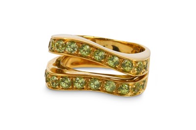 Lot 384 - A peridot dress ring, the bifurcated front of...
